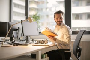 Businessman looks up from his desk and smiles.