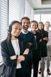 smiling customer service representatives stand in a line at the office and smile