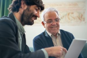 insurance agent goes over a life insurance policy with a smiling, elderly client