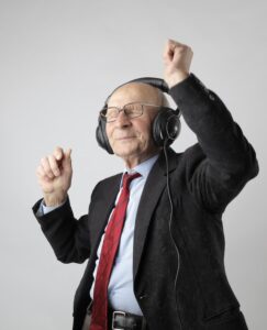 elderly businessman celebrating by dancing to music on his headphones