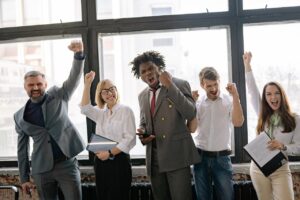 business team celebrates a victory in their office