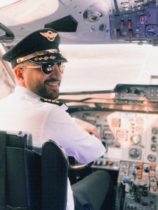 smiling pilot sitting in the cockpit of a plane