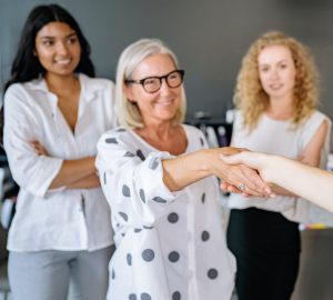 satisfied female client shaking hands with their insurance agent