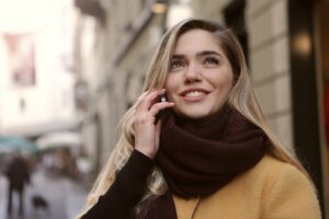 a happy woman walks in the city while talking to customer service over the phone about her life insurance policy